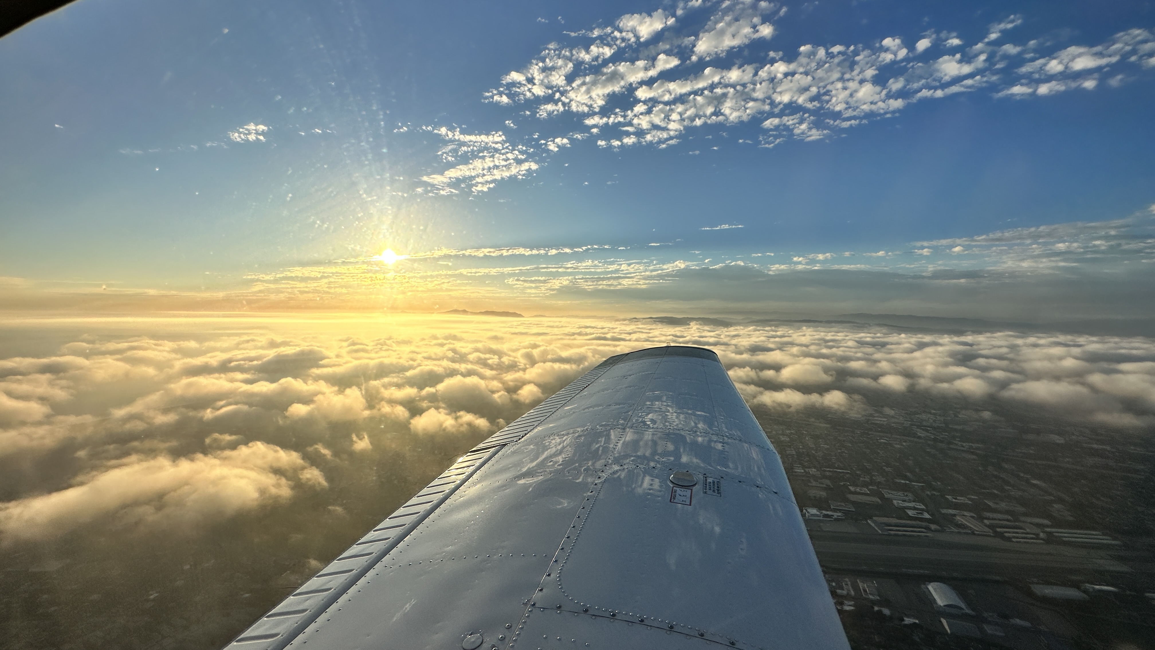 Placeholder image of a view from an airplane cockpit showing the horizon at sunset